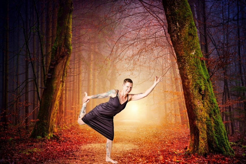 Sabine Scholze steht in der Figur der Tänzerin (Yoga)vor einer Waldkulisse.