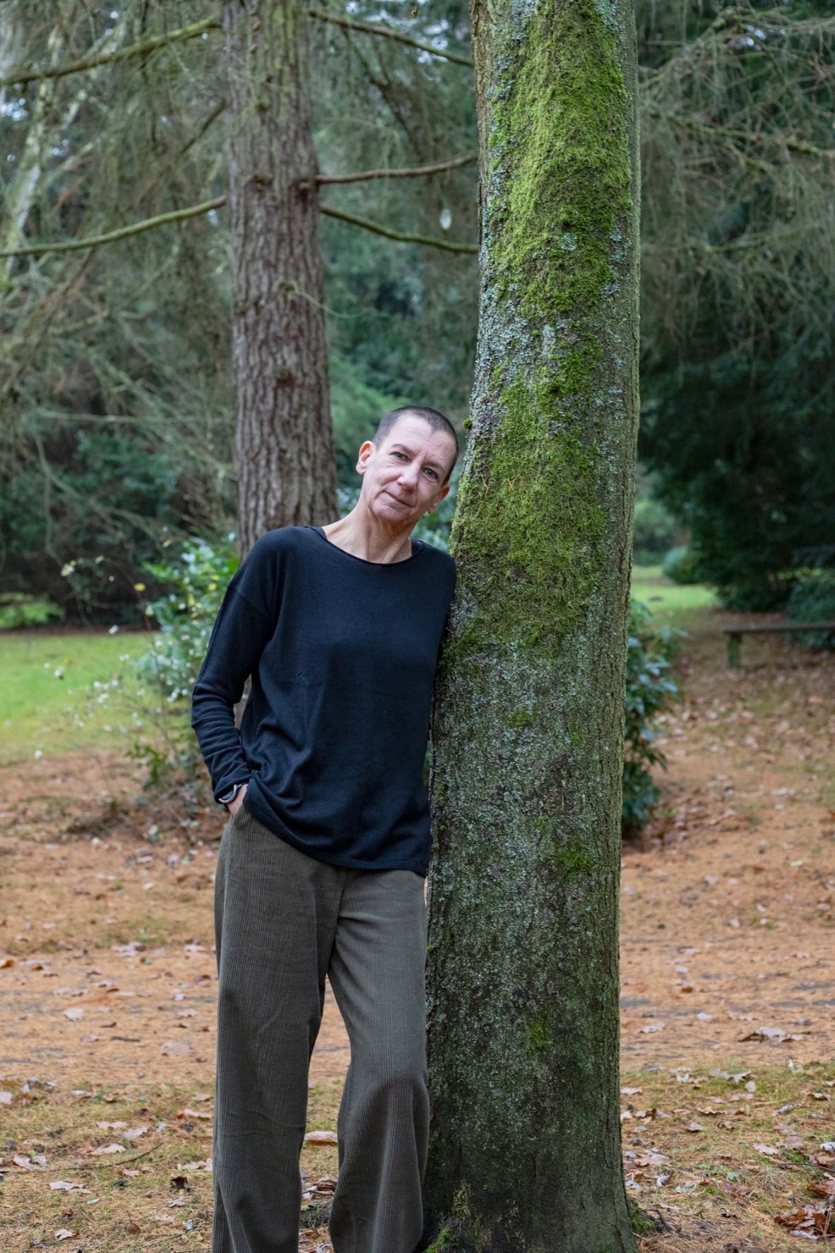 Das Beitragsbild zur Mission: Sabine Scholze lehnt an einem Baum. Fotografiert von Sabine Prilop auf dem Göttinger Stadtfriedhof.